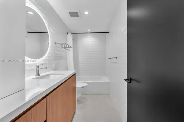 a bathroom with a granite countertop sink a toilet and shower