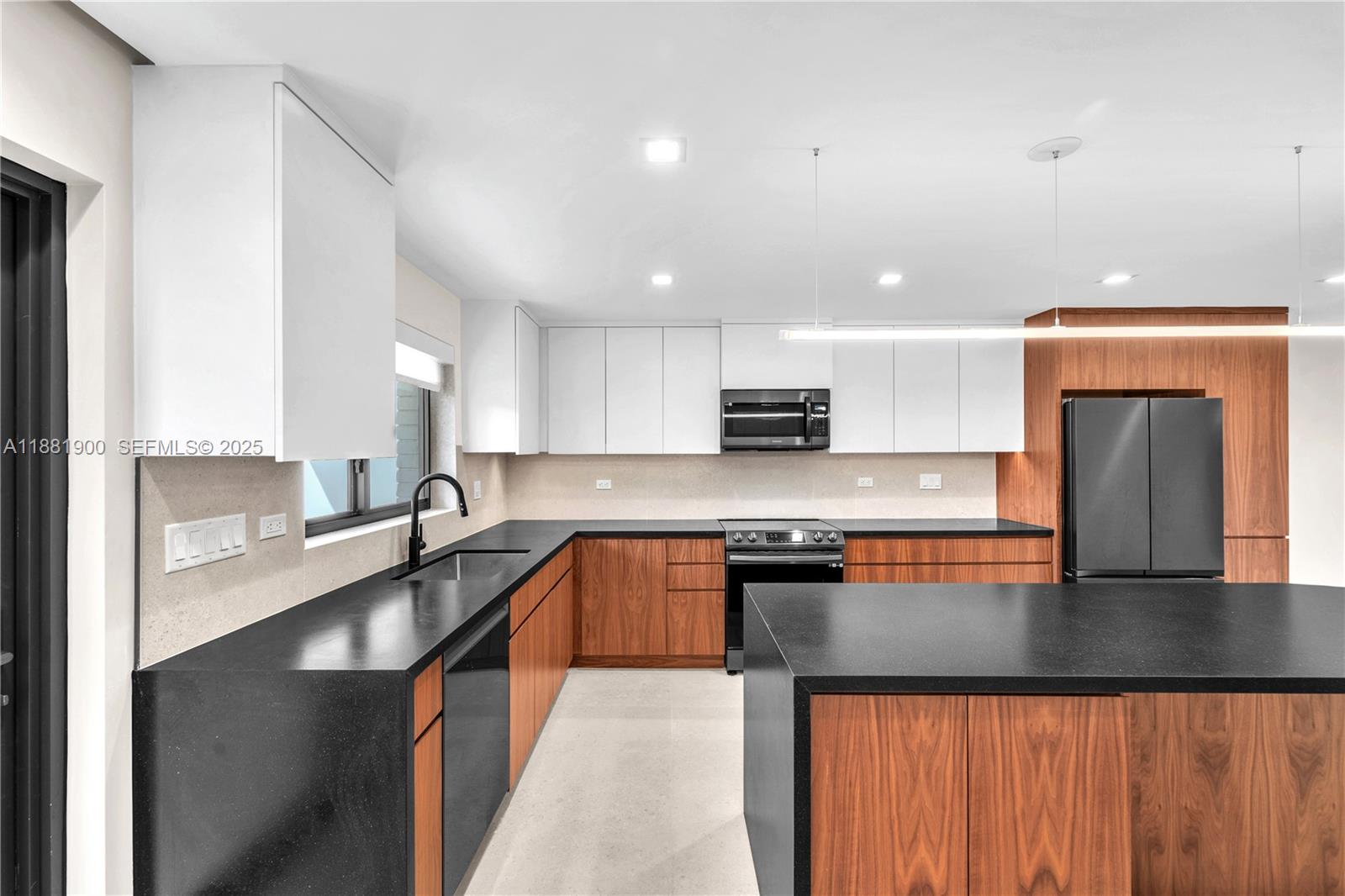 2211 Northeast 122nd Street, Unit 2211 North Miami, FL 33181 - Photo 7 of 34 a large kitchen with stainless steel appliances granite countertop a sink counter space and a stove top oven