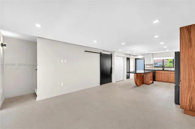 a view of an empty room with kitchen