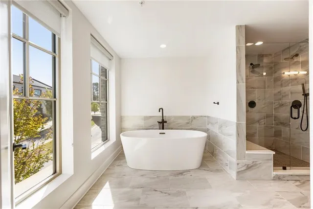 a bathroom with a tub shower and mirror