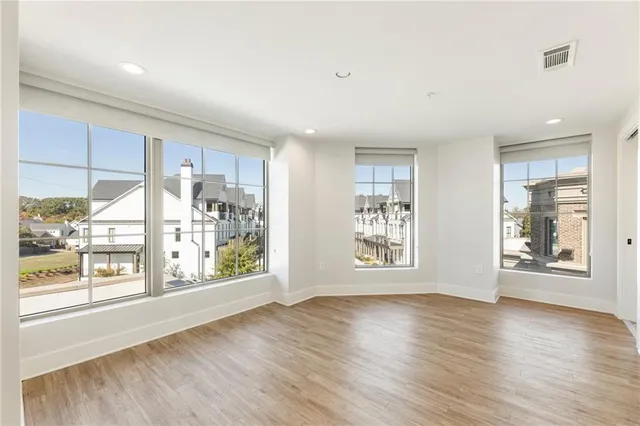an empty room with wooden floor and windows