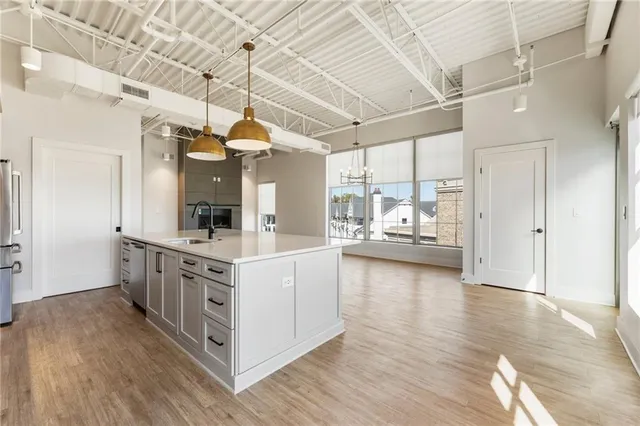 a large kitchen with cabinets wooden floor and stainless steel appliances
