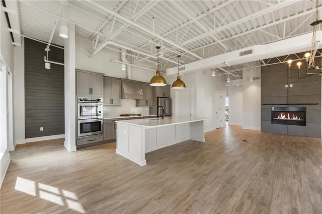 a kitchen with stainless steel appliances granite countertop a sink a stove and refrigerator