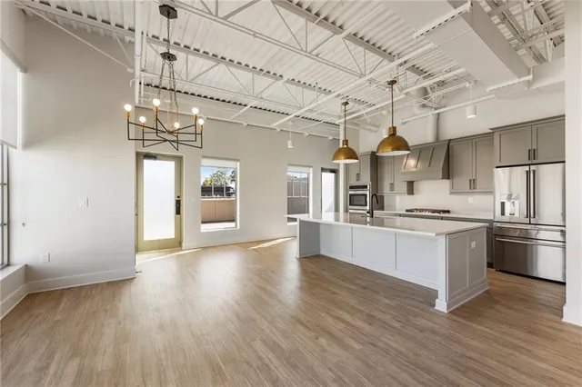 a kitchen with stainless steel appliances a refrigerator a sink a stove and white cabinets