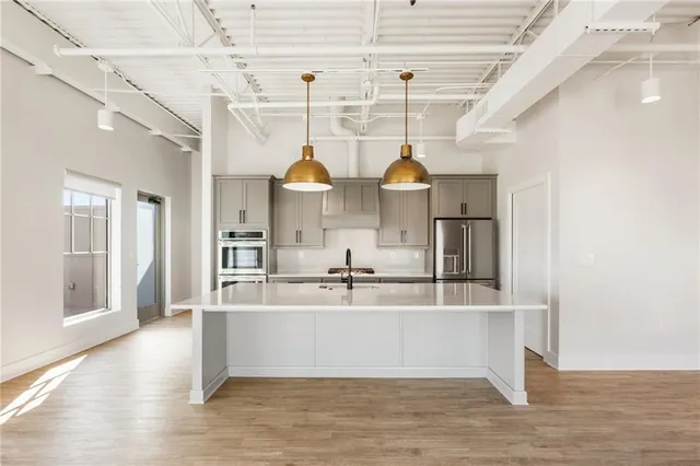 a large kitchen with kitchen island a stove a sink dishwasher and white cabinets with wooden floor