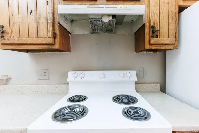 a kitchen with a stove and cabinets
