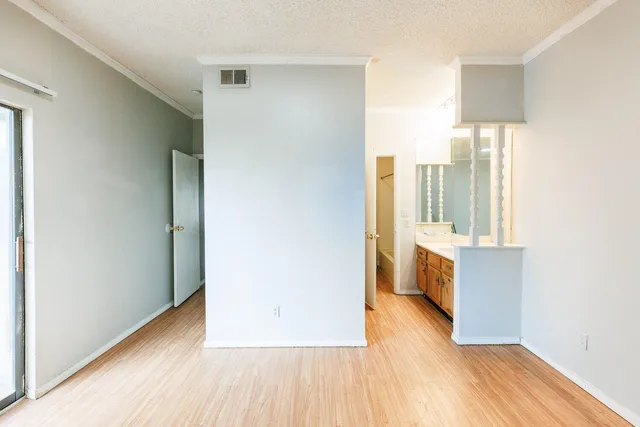 a view of a hallway with wooden floor and cabinet
