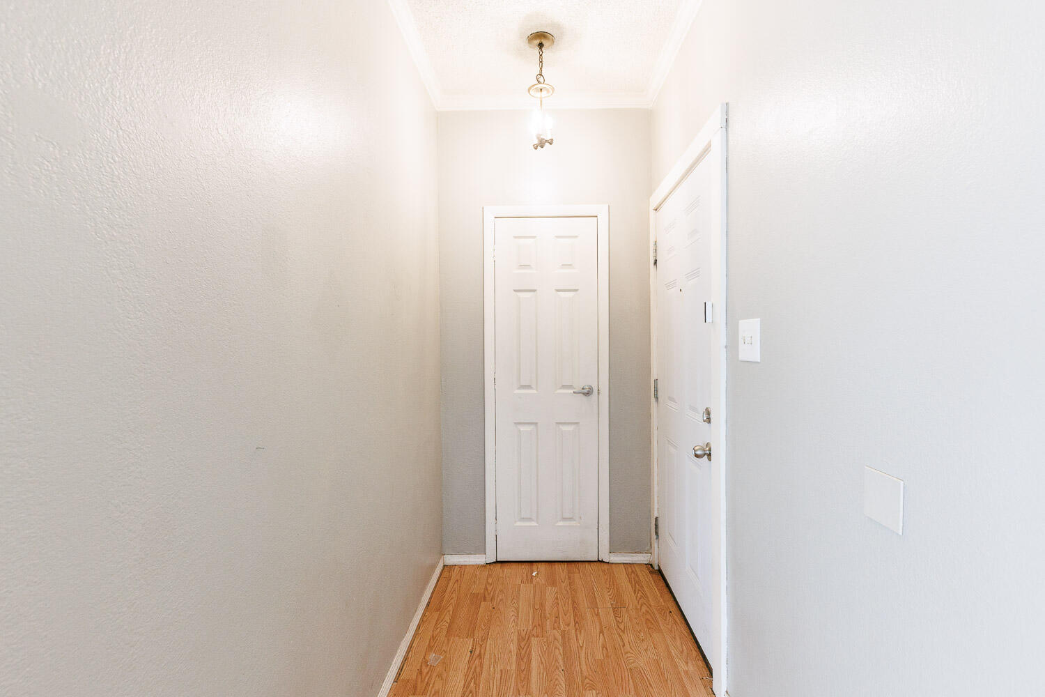 7405 Avenue X, Unit 103 Lubbock, TX 79423 - Photo 3 of 33 a view of a hallway with wooden floor and a bathroom