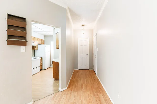a view of a hallway with wooden floor and staircase