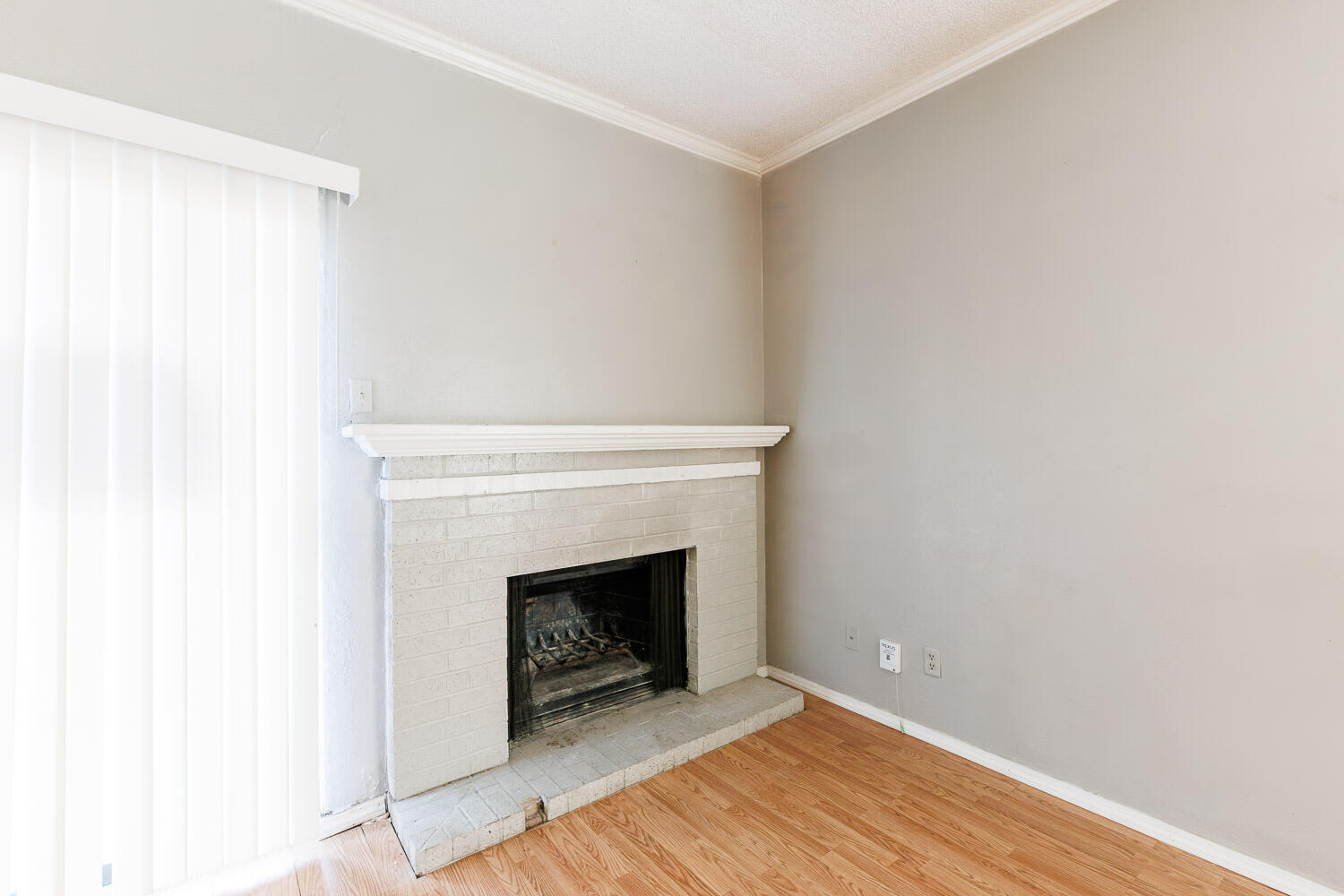 7405 Avenue X, Unit 103 Lubbock, TX 79423 - Photo 7 of 33 a view of an empty room with wooden floor and a fireplace