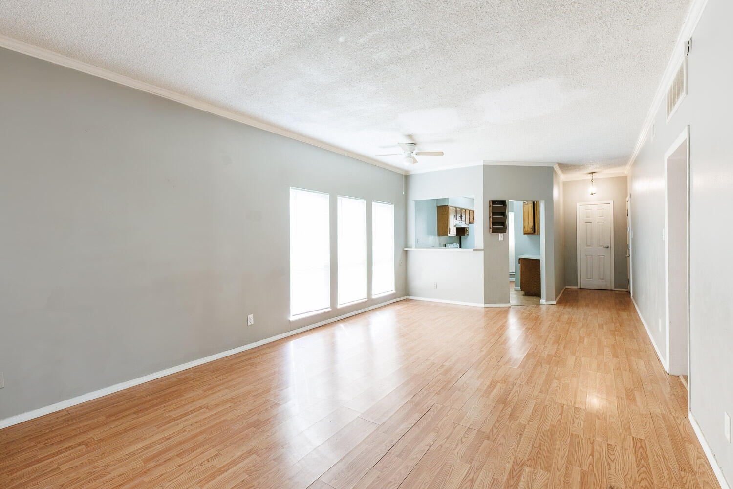 7405 Avenue X, Unit 103 Lubbock, TX 79423 - Photo 9 of 33 a view of an empty room with wooden floor and a window