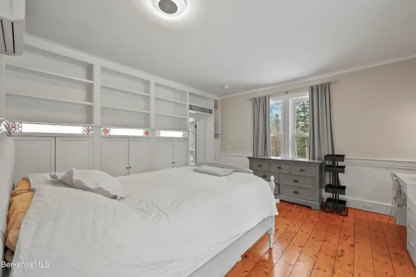 a bedroom with a bed and a large window