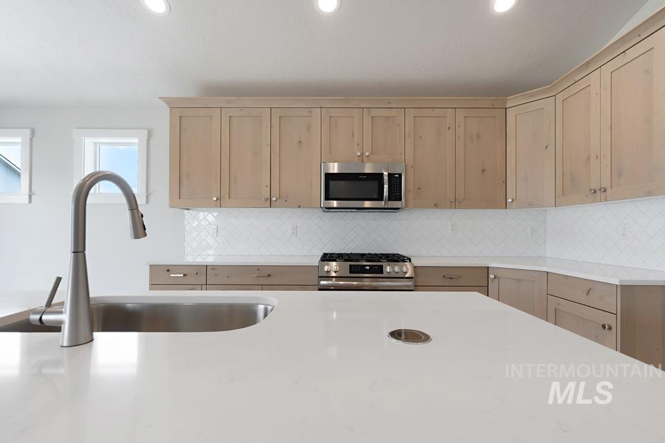 1355 Crescent Street Weiser, ID 83672 - Photo 13 of 31 Kitchen with stainless steel appliances, light countertops, decorative backsplash, recessed lighting, and light brown cabinets