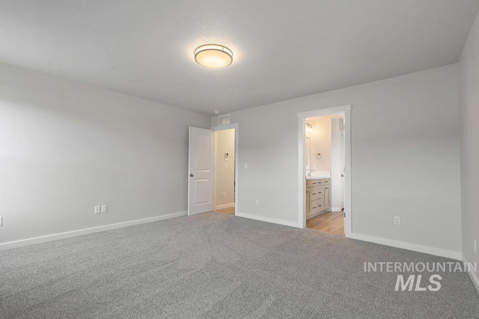 1355 Crescent Street Weiser, ID 83672 - Photo 18 of 31 Unfurnished bedroom with light colored carpet and connected bathroom