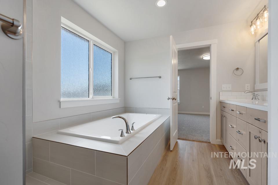 1355 Crescent Street Weiser, ID 83672 - Photo 22 of 31 Bathroom featuring vanity, a bath, and wood finished floors
