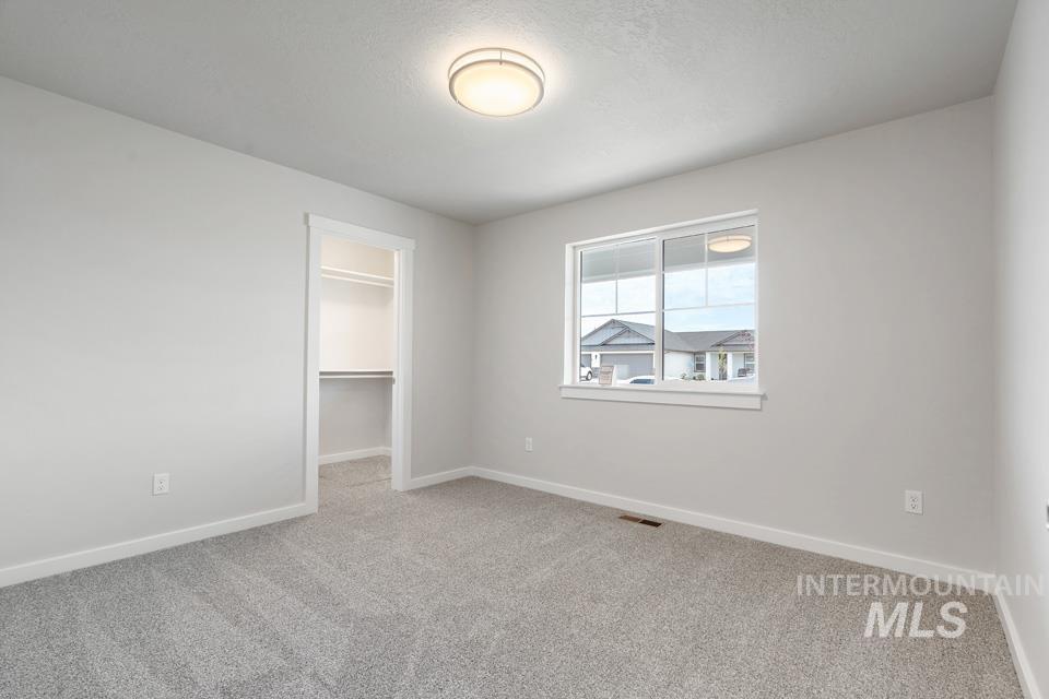 1355 Crescent Street Weiser, ID 83672 - Photo 7 of 31 Unfurnished bedroom featuring carpet flooring, a walk in closet, and a closet