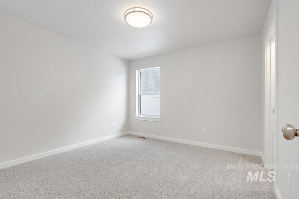 1355 Crescent Street Weiser, ID 83672 - Photo 9 of 31 Spare room featuring light colored carpet and baseboards