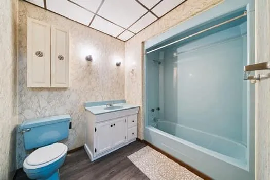 a bathroom with a granite countertop sink a toilet and shower