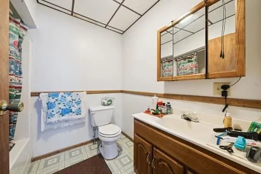 a bathroom with a sink a toilet and shower curtain