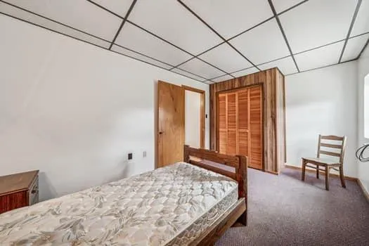 a bed sitting in a spacious bedroom next to a window