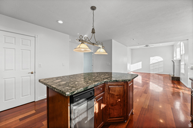 4117 North Wolf Ridge Circle Eden, UT 84310 - Photo 11 of 63 Kitchen island featuring a granite countertop, wood-finish cabinetry, and an integrated dishwasher