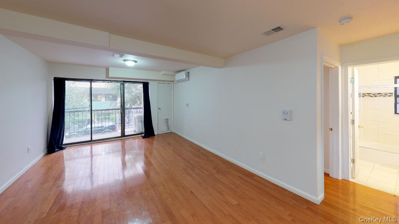 110-19 72nd Road, Unit 3A Queens, NY 11375 - Photo 4 of 20 a view of an empty room with wooden floor and a window
