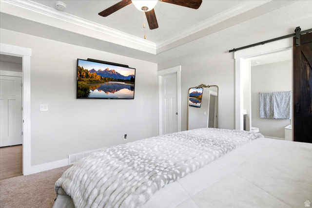2973 West Red Sand Rd Haven Ogden, UT 84401 - Photo 30 of 30 Recessed ceiling with crown molding, ceiling fan with light fixture, light gray wall color, barn door entry, and carpeted flooring