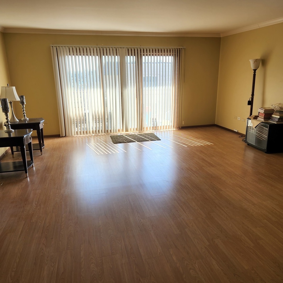 6441 West Warner Avenue, Unit 506 Chicago, IL 60634 - Photo 7 of 15 an empty room with wooden floor and windows
