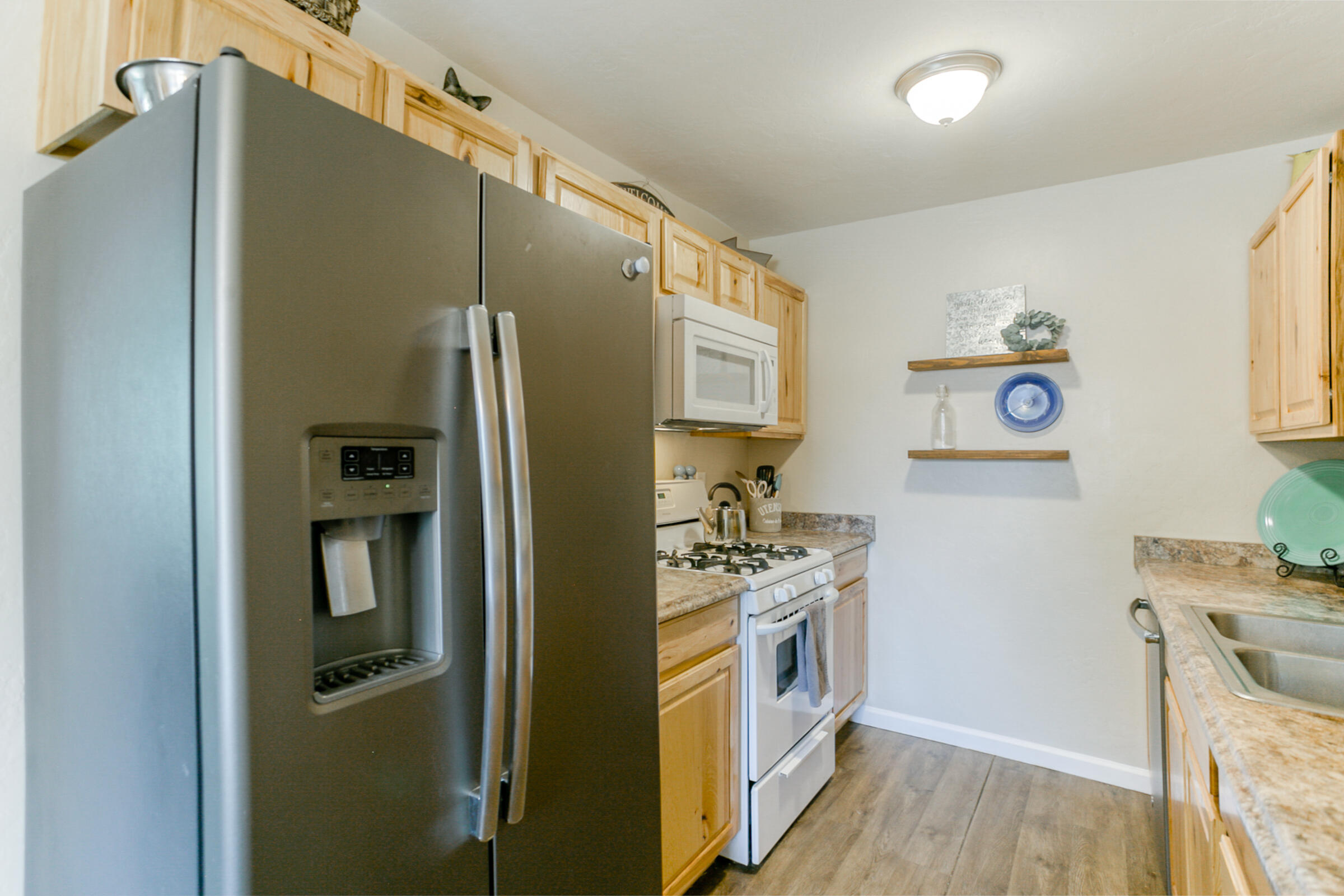 2498 Saturn Redding, CA 96002 - Photo 12 of 40 a kitchen with stainless steel appliances a refrigerator a stove a sink a chimney and wooden floor