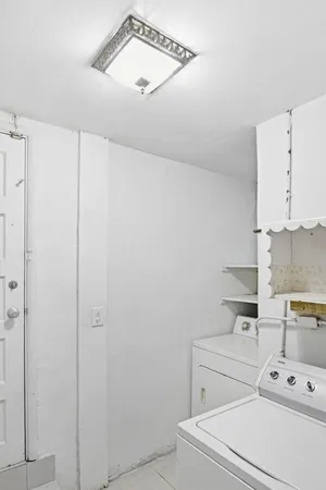 a view of washer and dryer with kitchen in the background