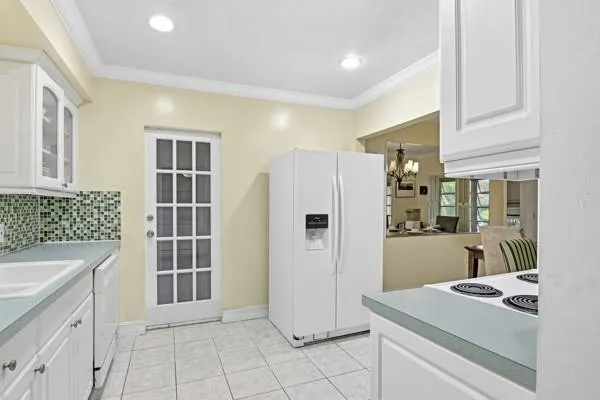 a kitchen that has a sink and a refrigerator in it
