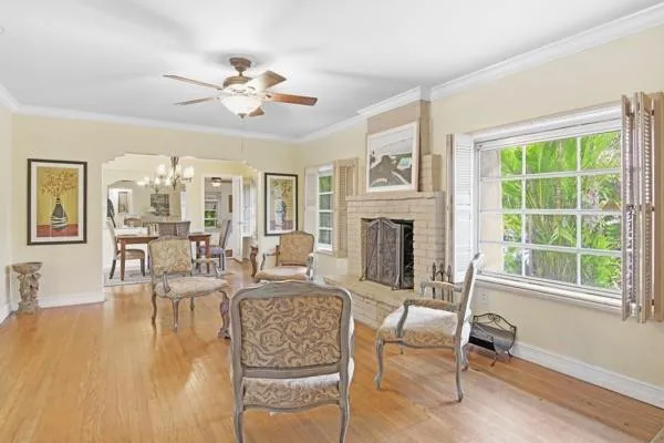 a living room with furniture a fireplace and a large window