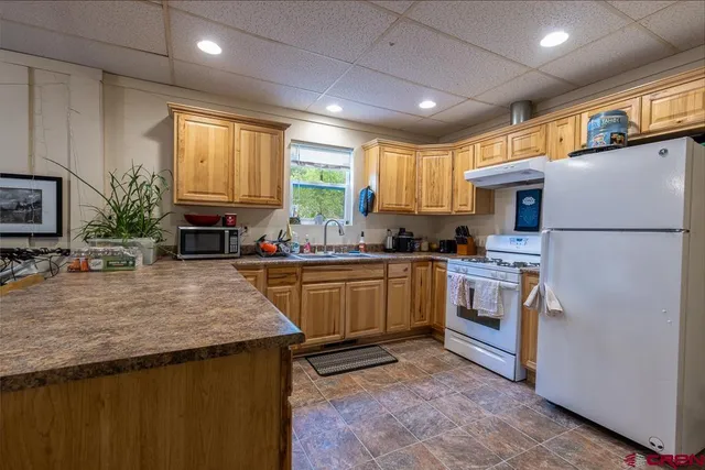 a kitchen with refrigerator a stove a sink cabinets and a counter top space