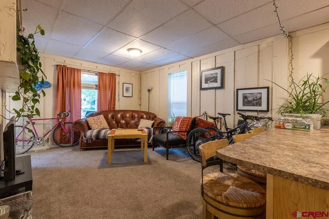 a living room with furniture a large window and potted plants
