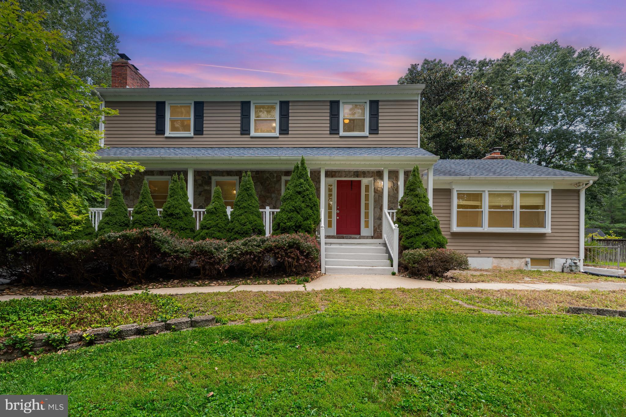 a front view of a house with a yard and potted plants