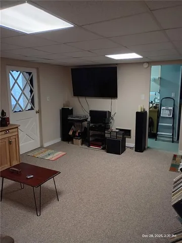 a living room with furniture a flat screen tv and gym equipment