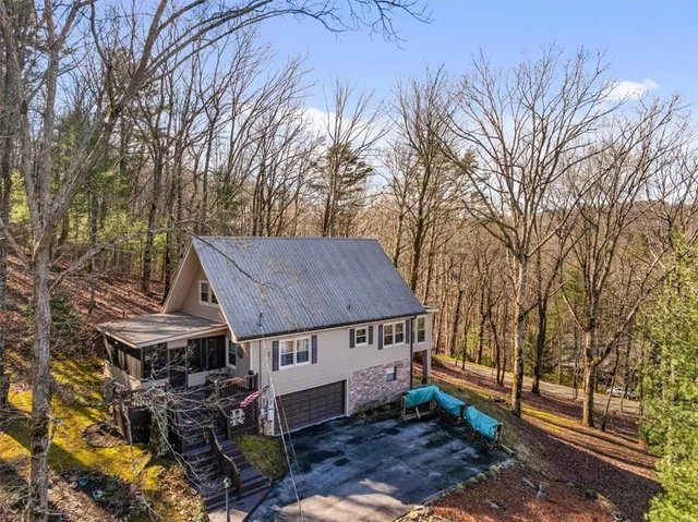 a view of a house with a yard and large trees