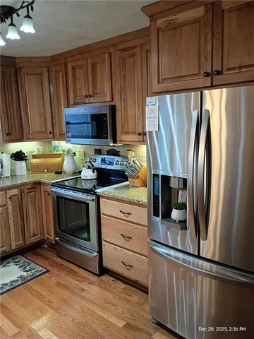 a kitchen with granite countertop a refrigerator stove and microwave