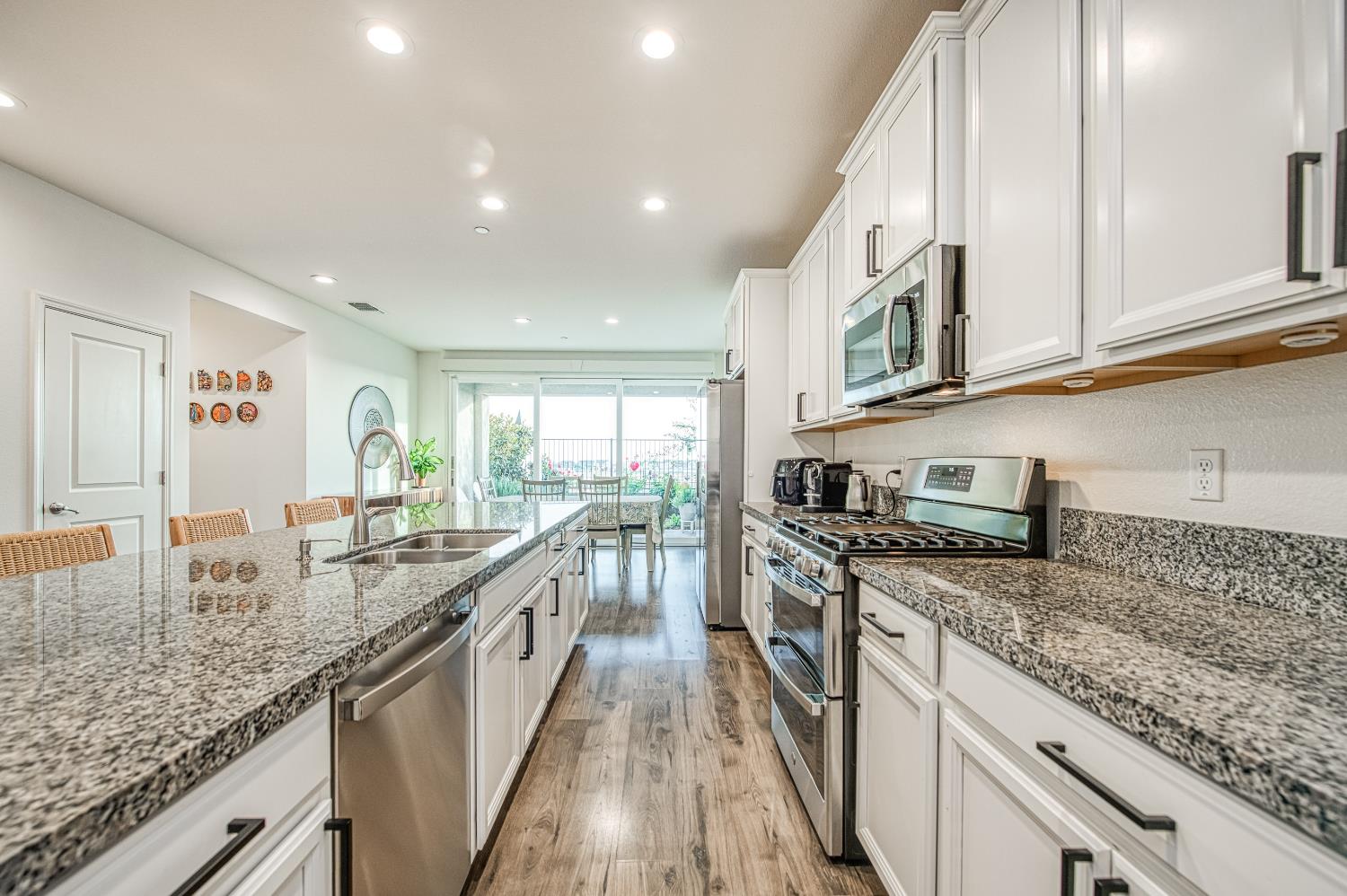 4284 Hillside Road Madera, CA 93636 - Photo 13 of 83 a kitchen with stainless steel appliances granite countertop a sink and stove top oven