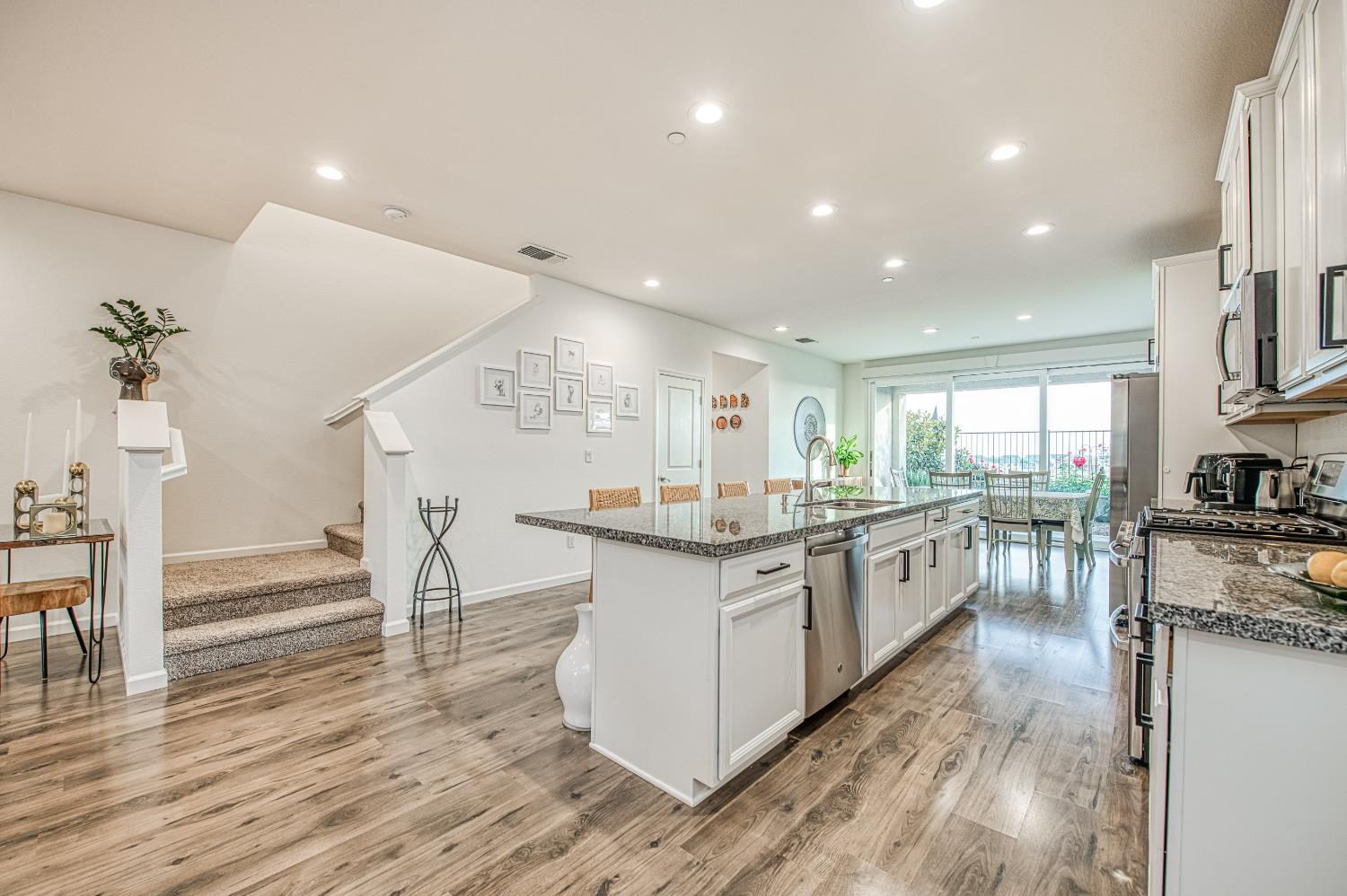 4284 Hillside Road Madera, CA 93636 - Photo 8 of 83 a kitchen with stainless steel appliances granite countertop a table chairs stove a refrigerator and cabinets