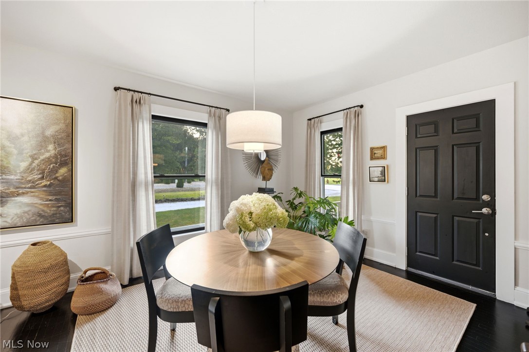 4122 Middle Ridge Road Perry, OH 44081 - Photo 13 of 50 Dining area featuring dark wood-finish flooring, white trim, and a contemporary drum pendant light