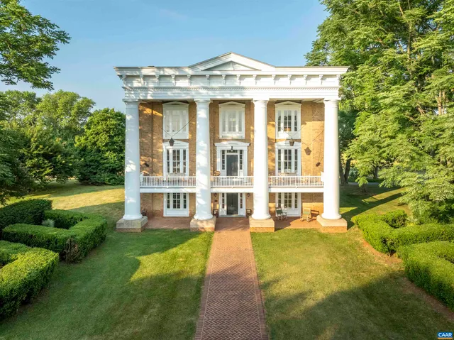 a view of a white building with a swimming pool