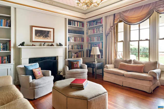 a living room with furniture fireplace and a large window