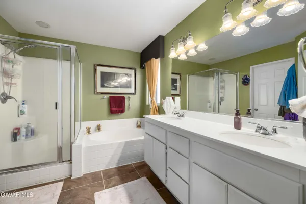 a bathroom with a sink a tub and a mirror