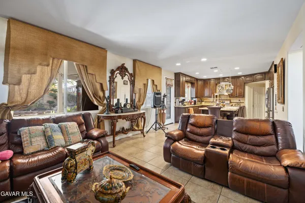a living room with furniture kitchen view and a large window