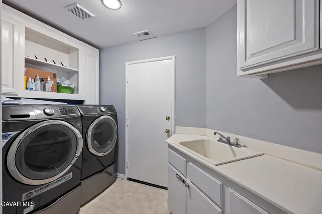 a utility room with sink dryer and washer