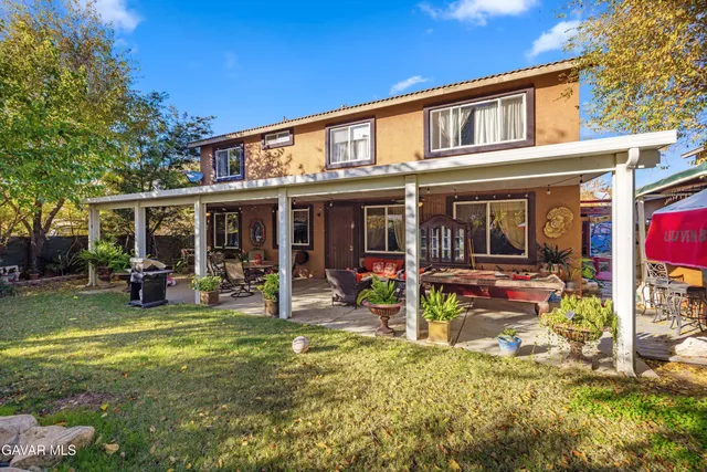a view of a house with a yard patio and sitting area