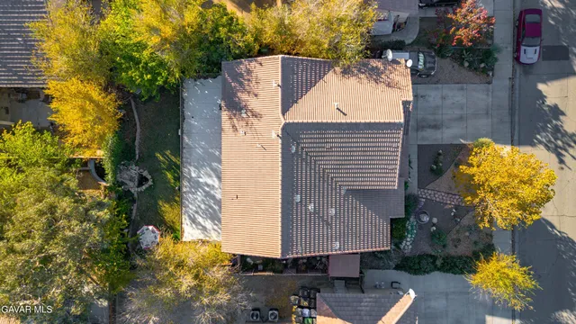 an aerial view of a house with swimming pool and large trees