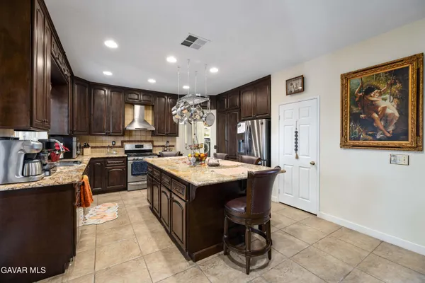 a kitchen with kitchen island granite countertop stainless steel appliances lots of counter top space