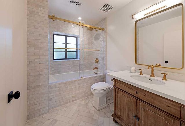 a bathroom with a double vanity sink toilet mirror and shower